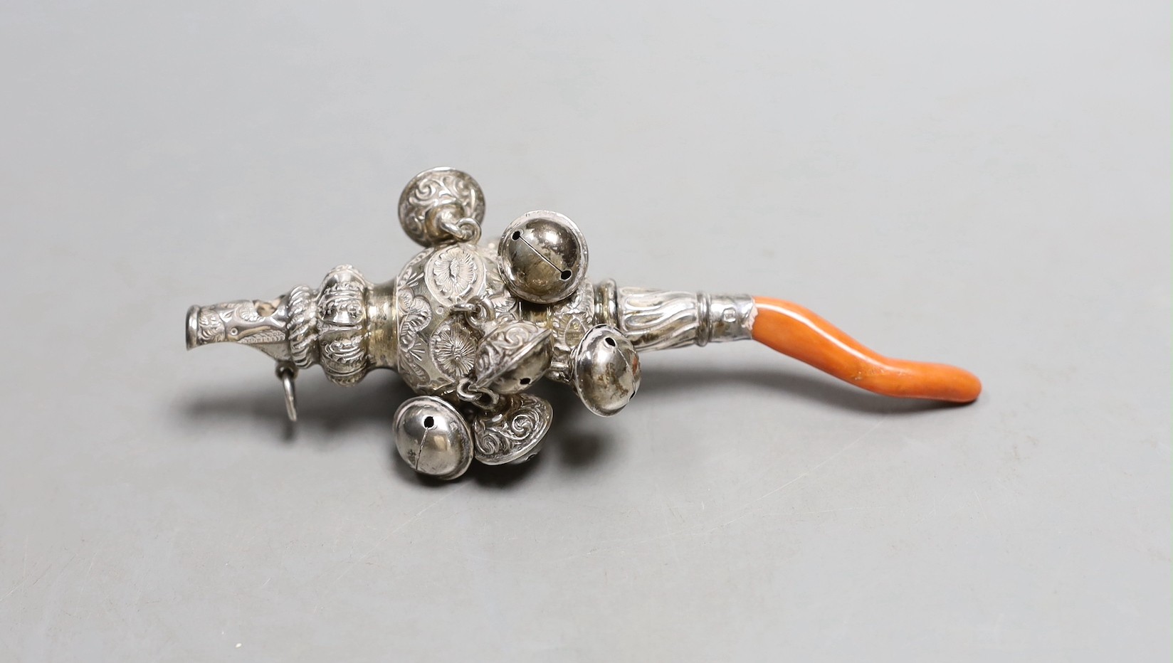A late Victorian silver baby’s rattle, with bells, whistle and coral teether, Hilliard & Thomasson, Birmingham, 1900, 12.3cm.
